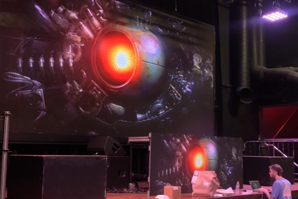 a stage with a large screen and a large red light